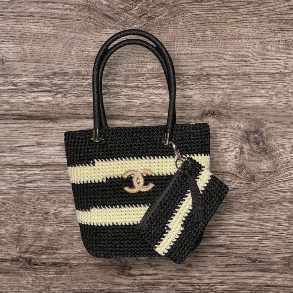 Aubergine purple crochet handbag with cream stripes, chain detail and black handles